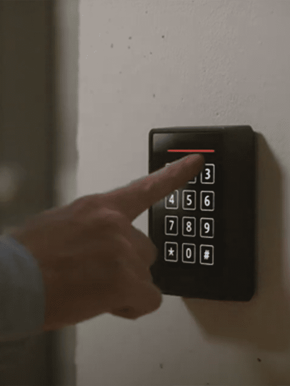 Personne composant le code de sécurité sur un digicode Tracor Europe afin d'ouvrir une porte